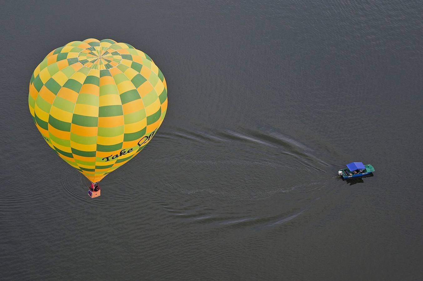 Varias personas asisten a la décima Fiesta Internacional de Globos Aerostáticos de Putrajaya (Malasia). Más de 20 globos aerostáticos volaron por los cielos en la fiesta anual, organizada para promover el turismo y los deportes de aviación. 