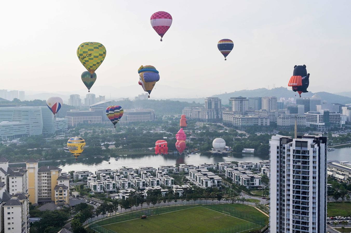 Varias personas asisten a la décima Fiesta Internacional de Globos Aerostáticos de Putrajaya (Malasia). Más de 20 globos aerostáticos volaron por los cielos en la fiesta anual, organizada para promover el turismo y los deportes de aviación. 