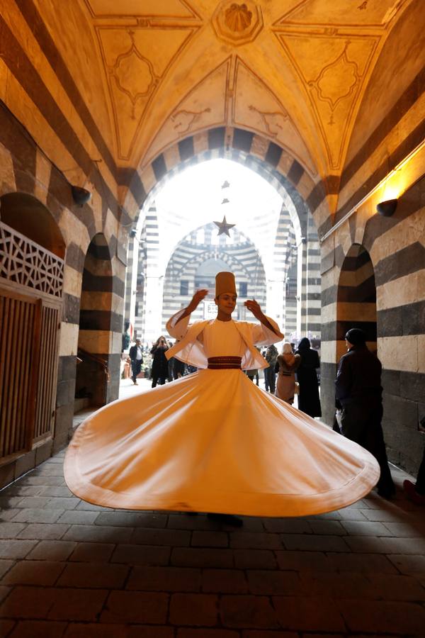Bailarines de derviches actúan durante el «Festival de los Panes Sirios» celebrado en Khan Asaad Basha para conmemorar el Año Nuevo sirio, en la antigua ciudad de Damasco (Siria). El evento se lleva a cabo bajo los auspicios del Ministerio de Turismo de Siria con la cooperación de la Unión de Artesanos. 