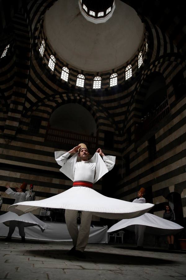 Bailarines de derviches actúan durante el «Festival de los Panes Sirios» celebrado en Khan Asaad Basha para conmemorar el Año Nuevo sirio, en la antigua ciudad de Damasco (Siria). El evento se lleva a cabo bajo los auspicios del Ministerio de Turismo de Siria con la cooperación de la Unión de Artesanos. 