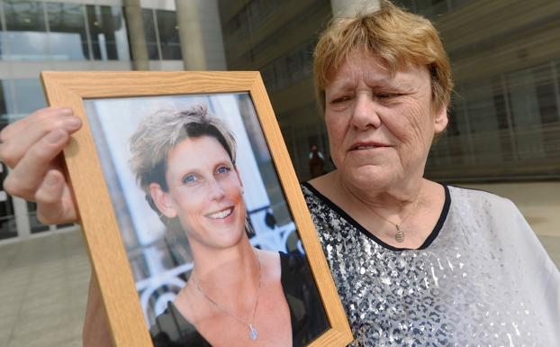 Patsy Visser, con la cruz de Caravaca en su cuello y un retrato de su hija Ingrid, en el que se la ve portando la misma alhaja. 