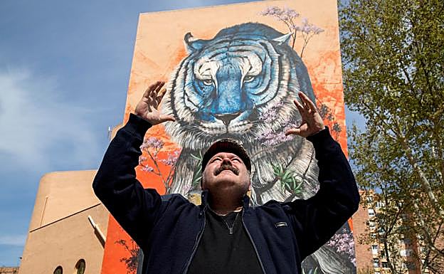 El artista Kraser, en un mural que pintó en un edificio de Cartagena, posa para el objetivo de 'La Verdad. 