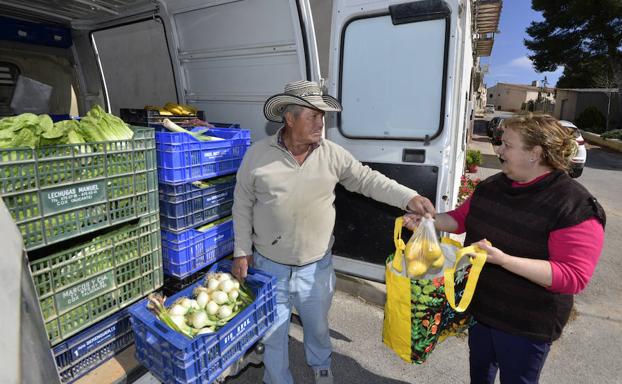 Una vecina compra a un vendedor ambulante en Torre del Rico. 