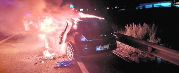 El coche envuelto en llamas tras el accidente.