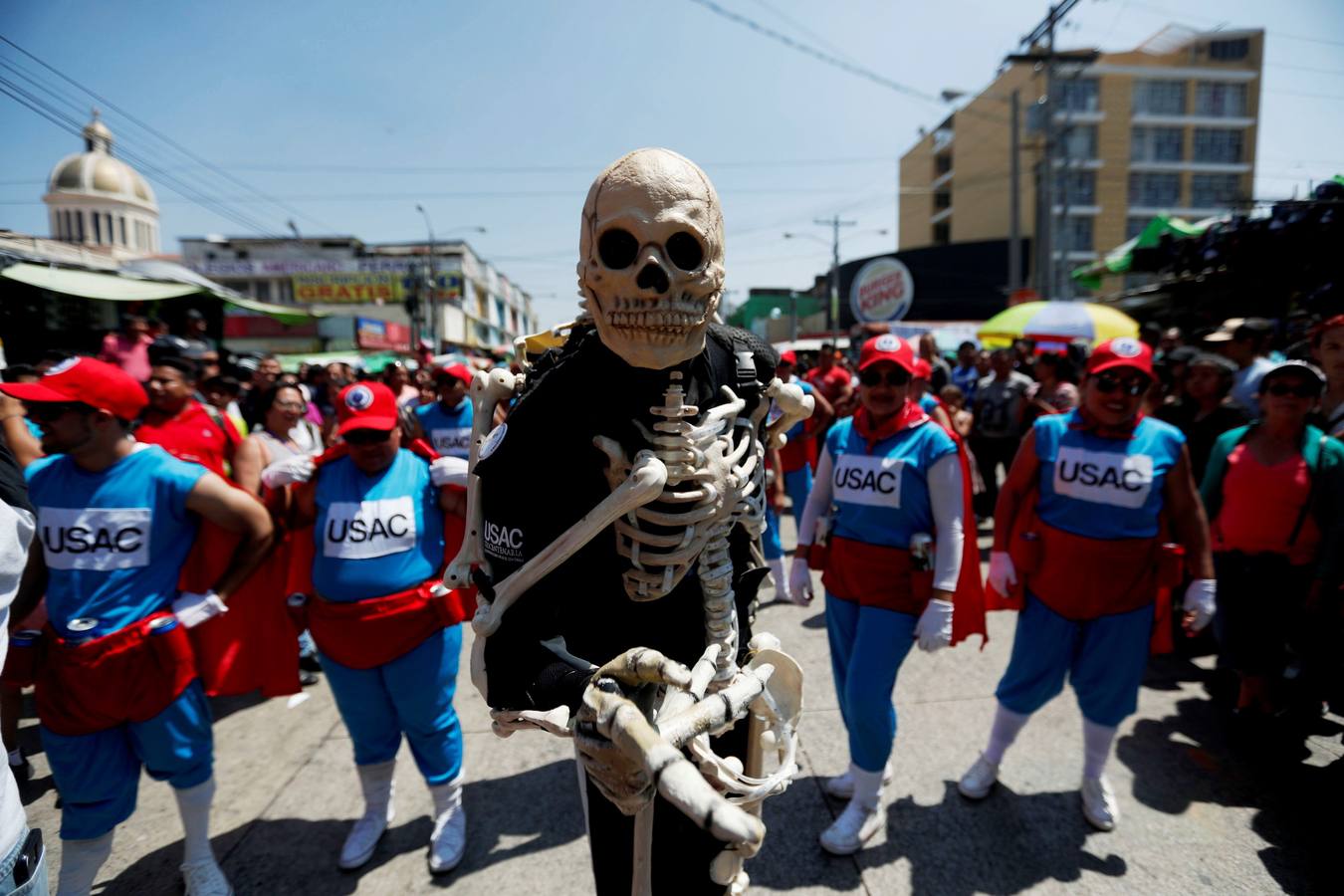 Estidiantes de la Universidad de San Carlos de Guatemala danzan disfrazados durante la histórica Huelga de Dolores, en la que los universitarios, con morbo, se mofan de los políticos que buscan la «Guayaba» (Presidencia).