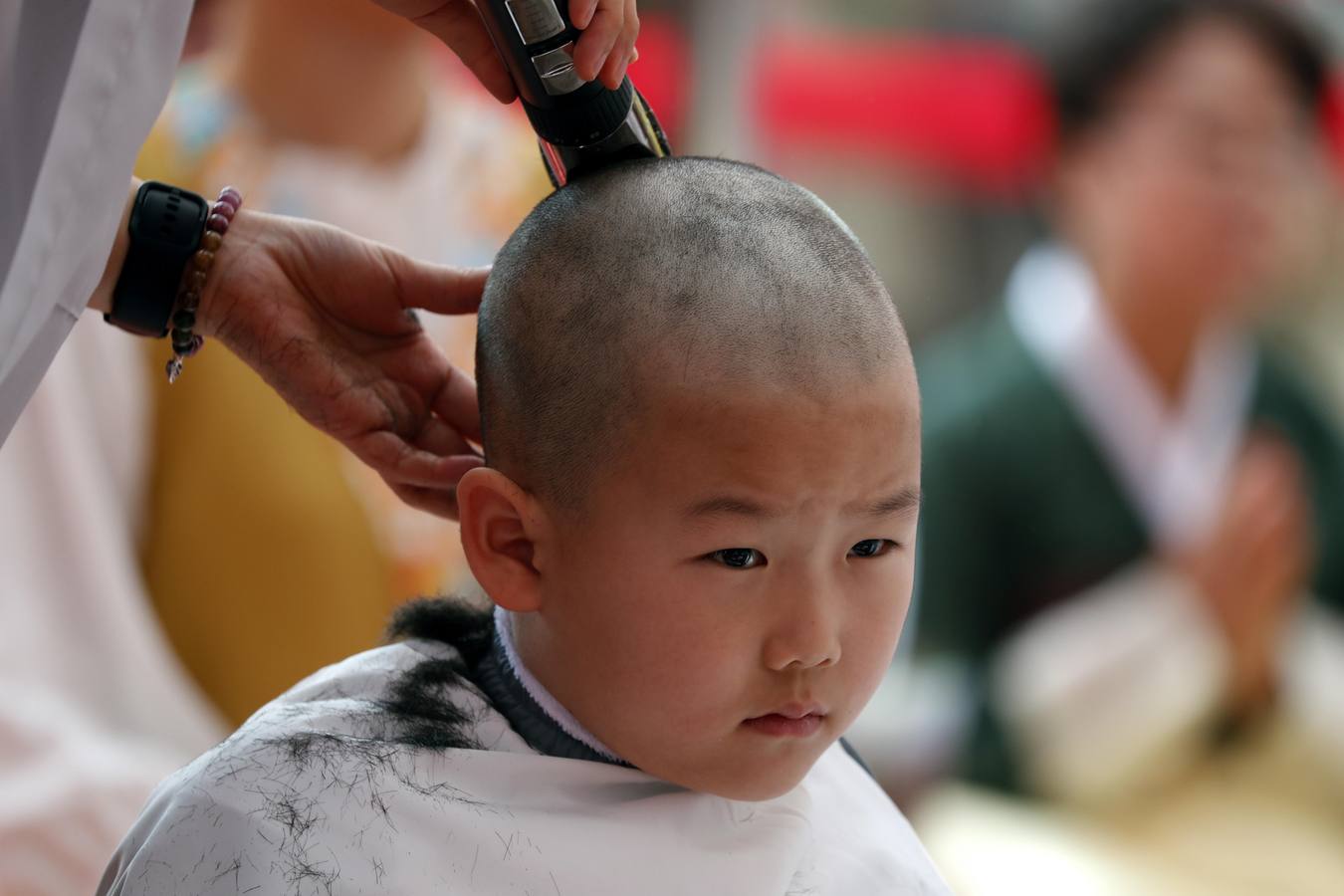 Varios niños reciben un drástico corte de pelo durante una ceremonia en la que menores surcoreanos se convierten en monjes budistas, en el templo Jogyesa de Seúl (Corea del Sur). Los monjes acogen a los niños en el templo durante 21 días para enseñarles los fundamentos de la religión budista.