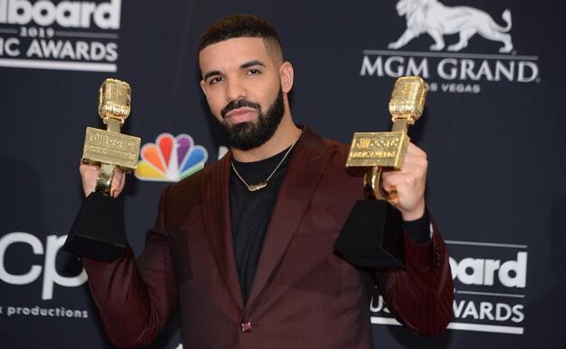 El rapero Drake posa sosteniendo dos de los doce galardones que ha ganado en los premios Billboard 2019.