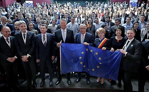 El presidente de la Comisión Europea, Jean-Claude Juncker (c), sostiene la bandera de la UE tras participar en una conferencia'.