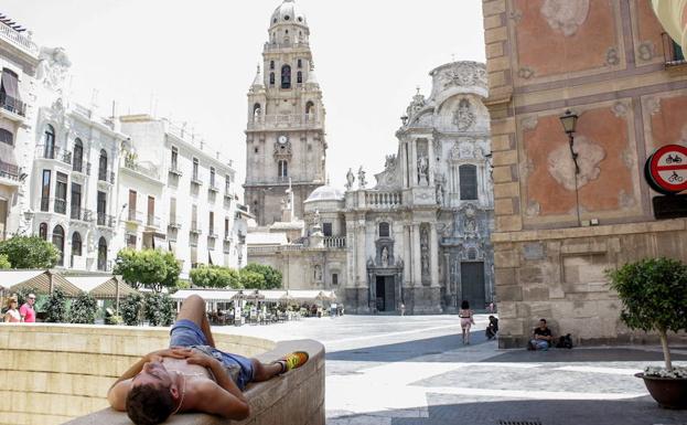 Un hombre se refugia en la sombra en un día de calor en Murcia, en una imagen de archivo.