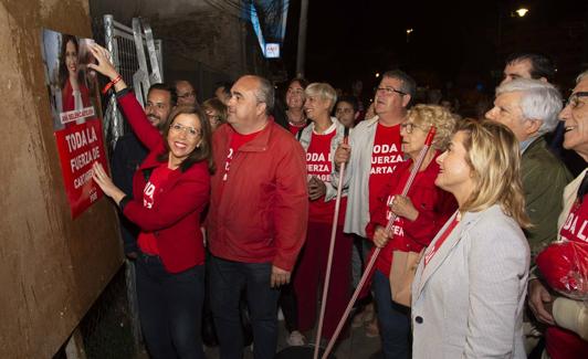 Ana Belén Castejón fija un cartel electoral en la calle Sagasta, rodeada de su equipo. 