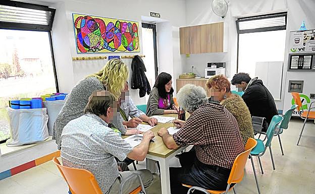 Usuarios del centro de día de Jesús Abandonado, en Murcia, realizan una dinámica de grupo en presencia de dos cuidadoras. 