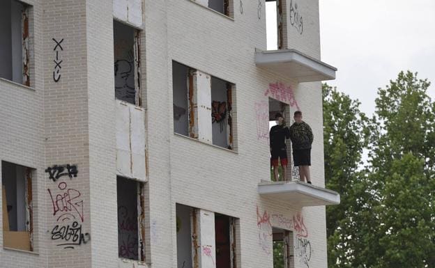 Dos jóvenes, asomados al que fue un balcón de uno de los bloques. 