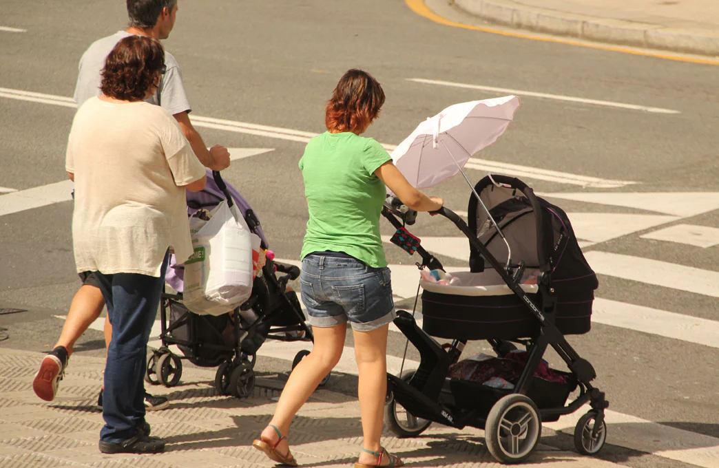 Dos mujeres pasean a sus bebés.