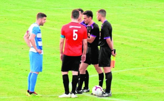 El árbitro habla con los capitanes antes de los penaltis. 