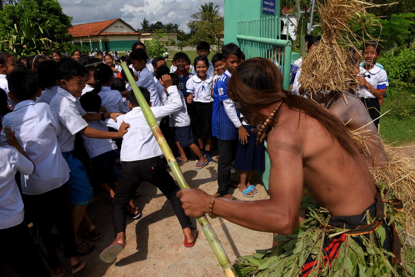 Varias personas participan en la ceremonia que honra la memoria de los espíritus del hogar de la aldea Pring Ka-Ek, este viernes en Nom Pen (Camboya). Los residentes buscan prevenir enfermedades y potenciar las cosechas a través de estos rituales milenarios.