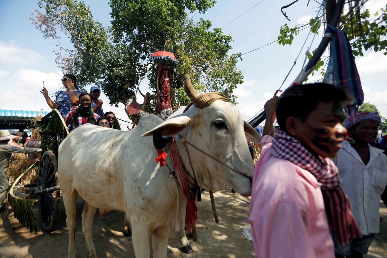 Varias personas participan en la ceremonia que honra la memoria de los espíritus del hogar de la aldea Pring Ka-Ek, este viernes en Nom Pen (Camboya). Los residentes buscan prevenir enfermedades y potenciar las cosechas a través de estos rituales milenarios.