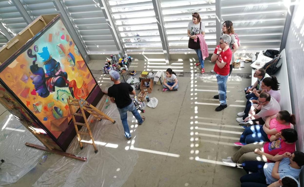 El público observa al artista urbano Mr. Chapu mientras da los últimos retoques a su obra, en el Muram. 