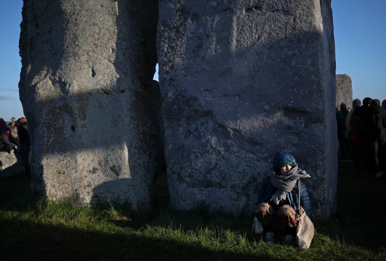 Varios entusiastas reciben el amanecer mientras participan en las celebraciones por el solsticio de verano en Stonehenge, en Wiltshire (Reino Unido). Este festival atrae anualmente a cientos de personas para celebrar el llegada del día más largo en el hemisferio norte.