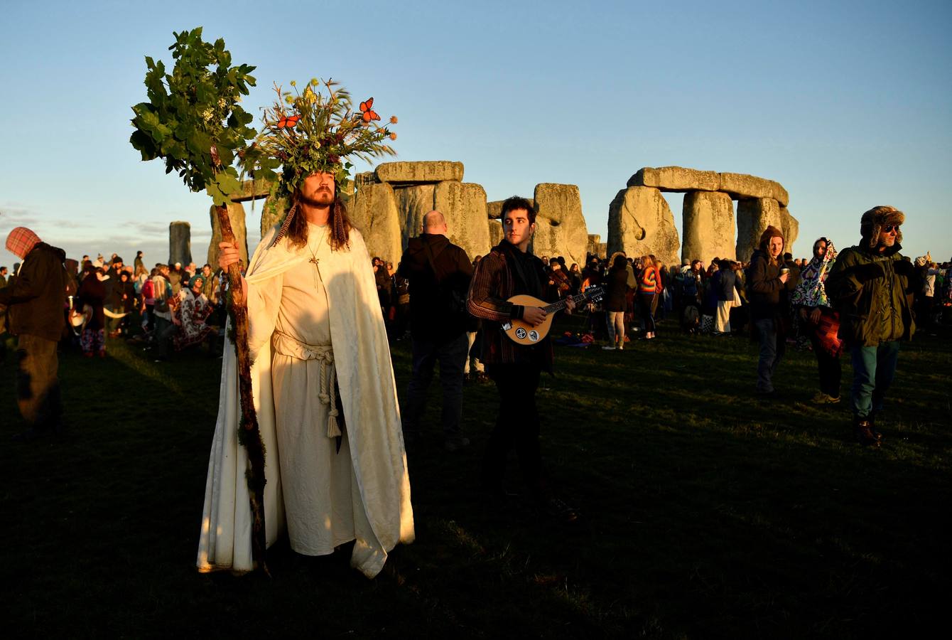 Varios entusiastas reciben el amanecer mientras participan en las celebraciones por el solsticio de verano en Stonehenge, en Wiltshire (Reino Unido). Este festival atrae anualmente a cientos de personas para celebrar el llegada del día más largo en el hemisferio norte.