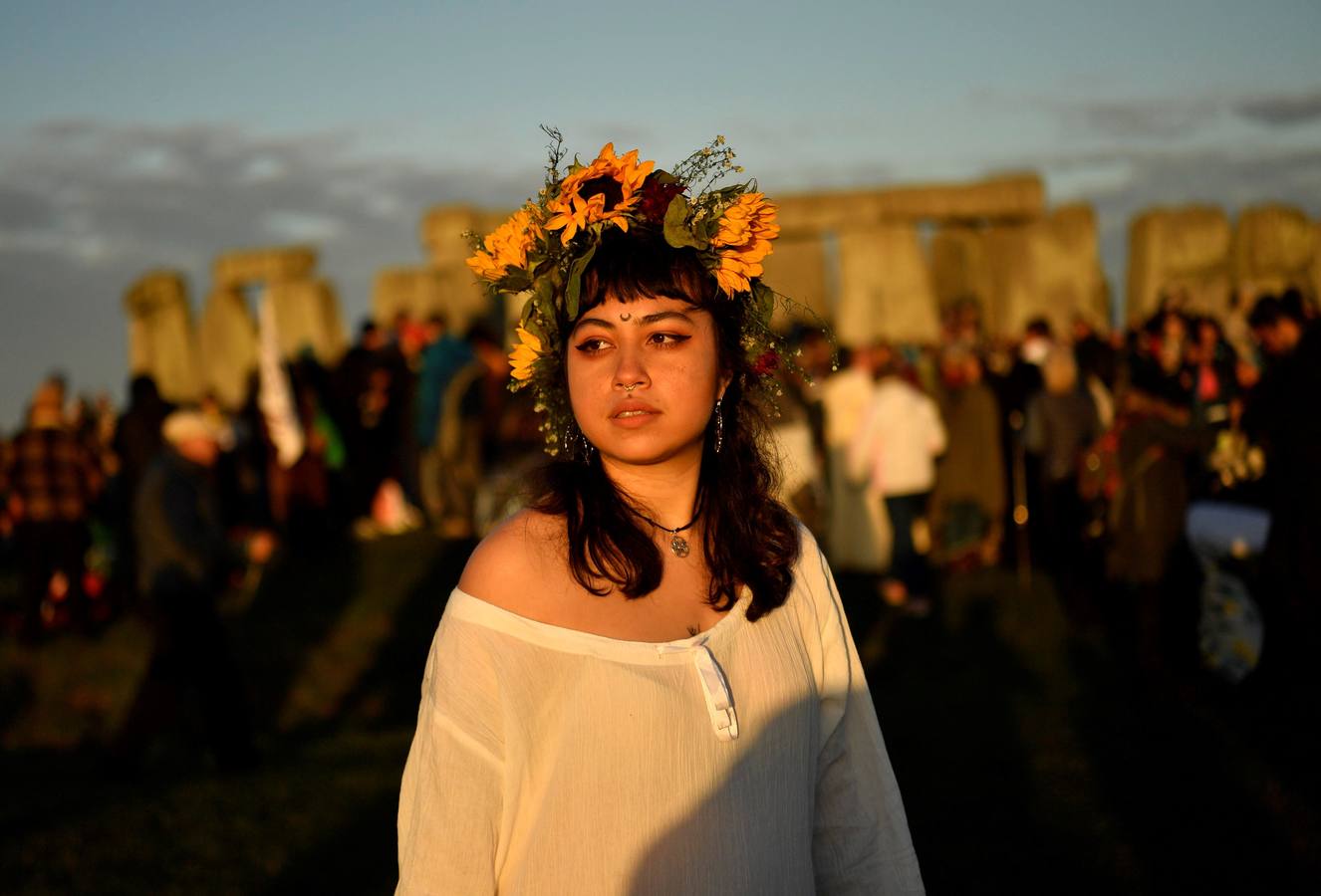 Varios entusiastas reciben el amanecer mientras participan en las celebraciones por el solsticio de verano en Stonehenge, en Wiltshire (Reino Unido). Este festival atrae anualmente a cientos de personas para celebrar el llegada del día más largo en el hemisferio norte.