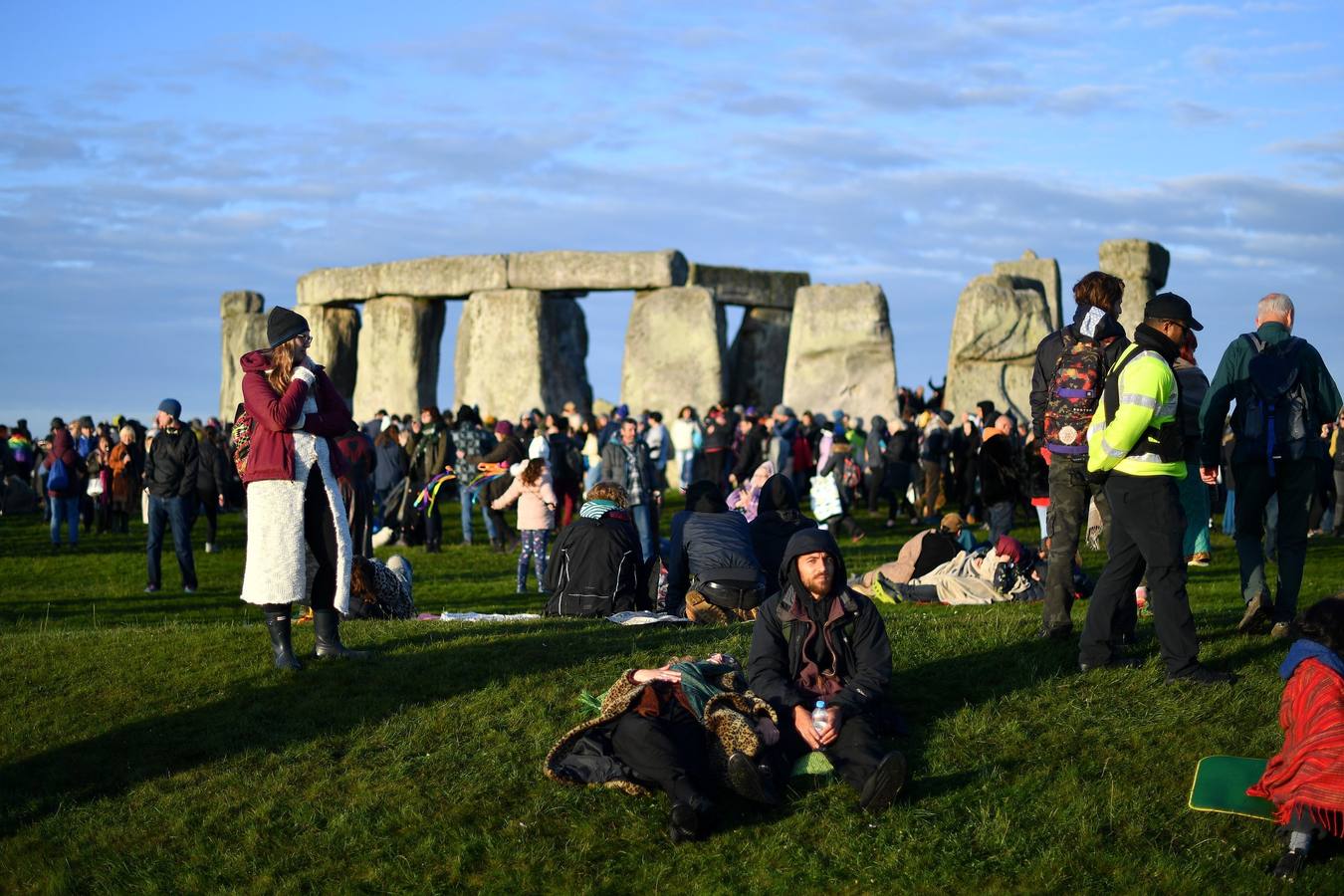 Varios entusiastas reciben el amanecer mientras participan en las celebraciones por el solsticio de verano en Stonehenge, en Wiltshire (Reino Unido). Este festival atrae anualmente a cientos de personas para celebrar el llegada del día más largo en el hemisferio norte.