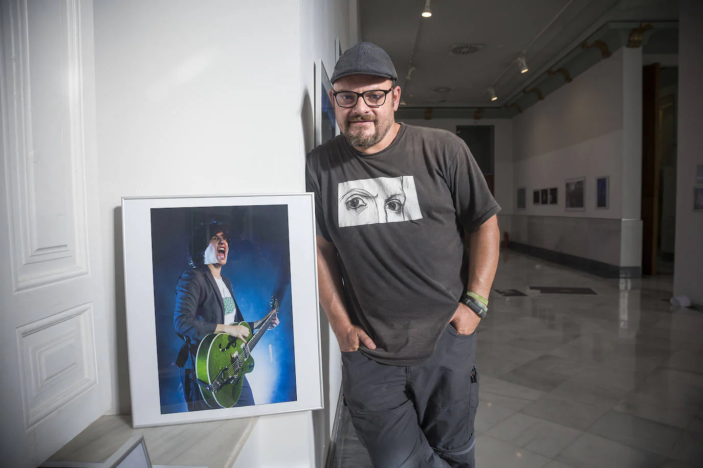 El fotógrafo de ‘La Verdad’ Pablo Sánchez, junto a una de las imágenes de la exposición conmemorativa de los 25 años de La Mar de Músicas, en Cartagena. 