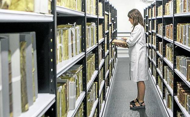 Eva Mínguez supervisa libros de iglesias y conventos. 