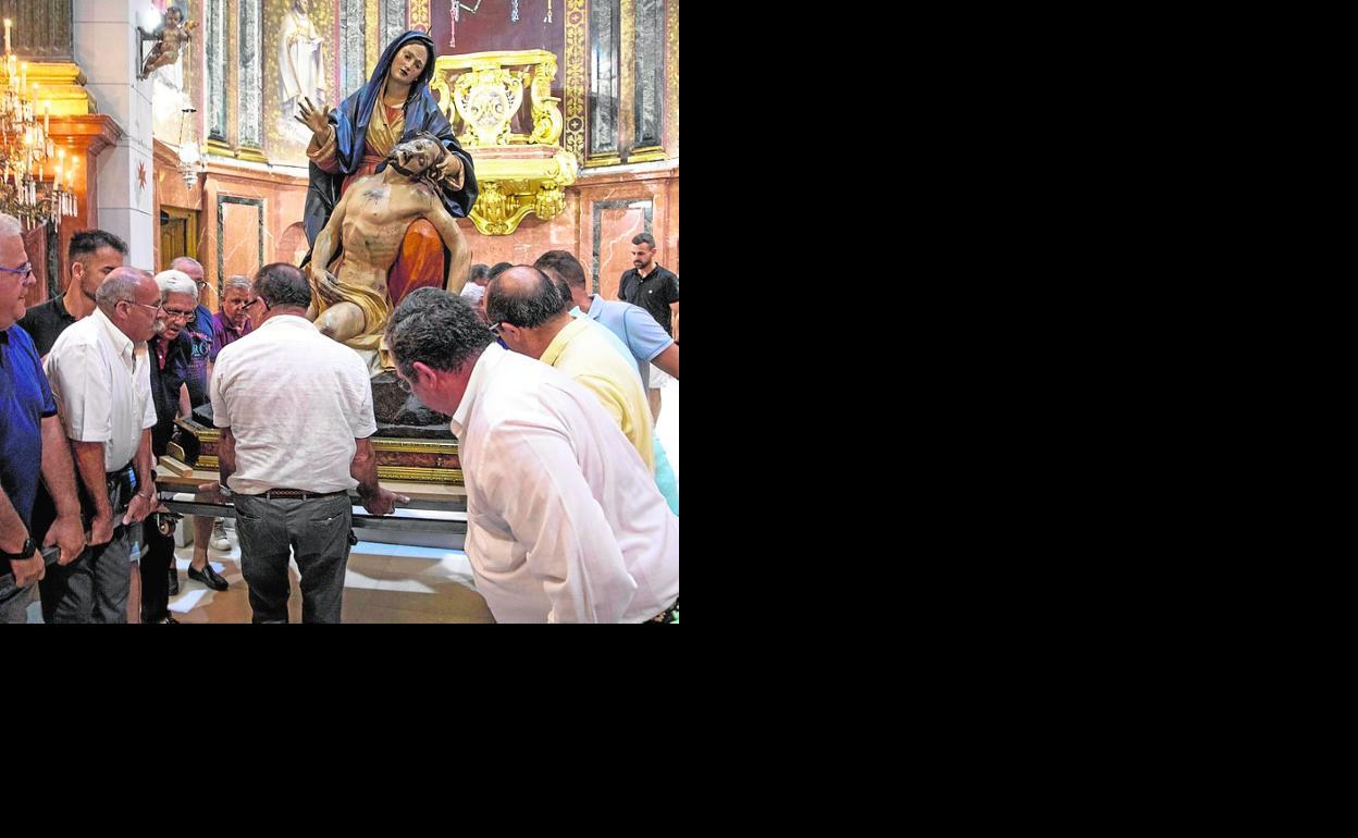 Maniobra para colocar a la Virgen tras bajarla de su altar. 