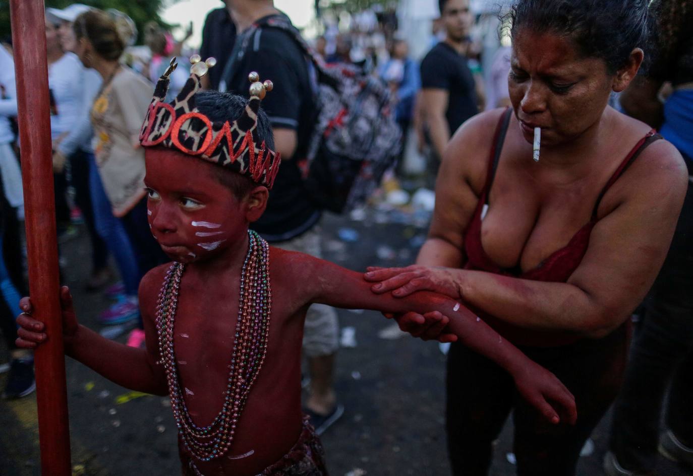 Varias personas llevan el cuerpo cubierto con aceite para cumplir con la tradición de «Los Diablitos Negros» durante una procesión en la que fieles católicos transportan la imagen de Santo Domingo de Guzmán, en Managua (Nicaragua). Como es tradición, la música pone el tono festivo y los creyentes bailan a la vez que avanzan hacia el norte de Managua, alrededor de la imagen, que es zangoloteada por los cargadores, como símbolo de alegría.