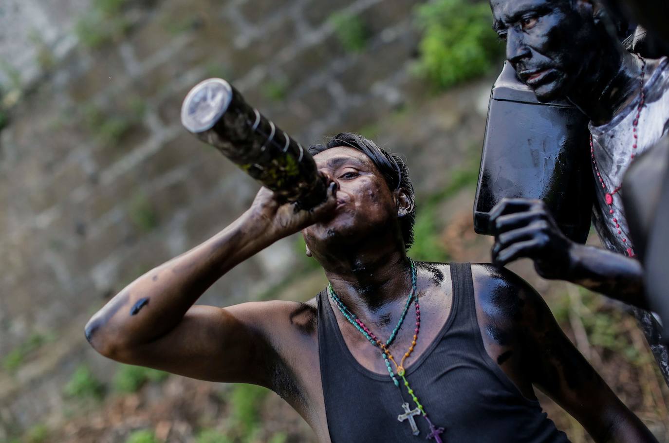 Varias personas llevan el cuerpo cubierto con aceite para cumplir con la tradición de «Los Diablitos Negros» durante una procesión en la que fieles católicos transportan la imagen de Santo Domingo de Guzmán, en Managua (Nicaragua). Como es tradición, la música pone el tono festivo y los creyentes bailan a la vez que avanzan hacia el norte de Managua, alrededor de la imagen, que es zangoloteada por los cargadores, como símbolo de alegría.