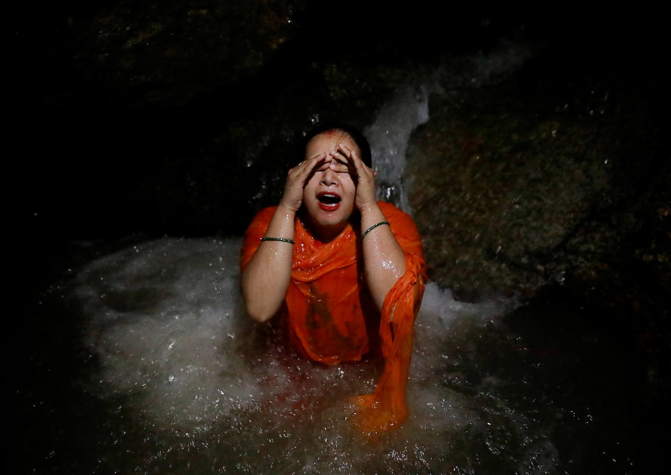 Varias personas peregrinan en honor a Shiva, dios de la creación y la destrucción, en Sundarijal, Nepal. Miles de devotos viajan descalzos hacia Sundarijal para honrar al dios Shiva y recolectar agua sagrada para limpiar todos sus pecados.