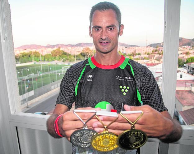 Joaquín López, en su casa, muestras las tres medallas conseguidas en China. 