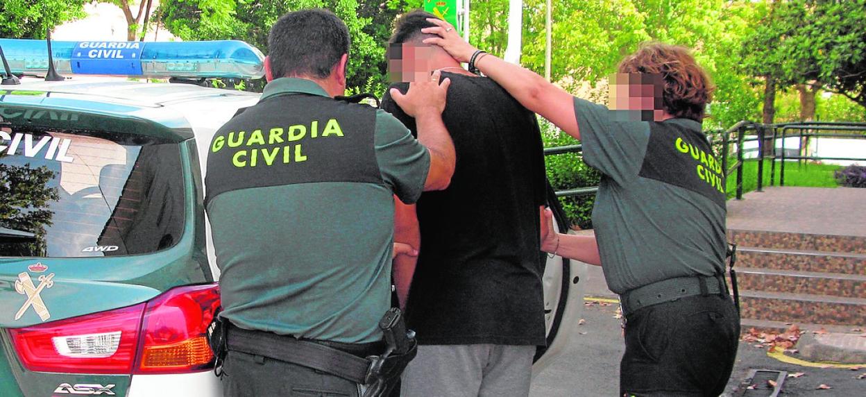Dos agentes introducen al sospechoso en el coche patrulla tras su arresto. 
