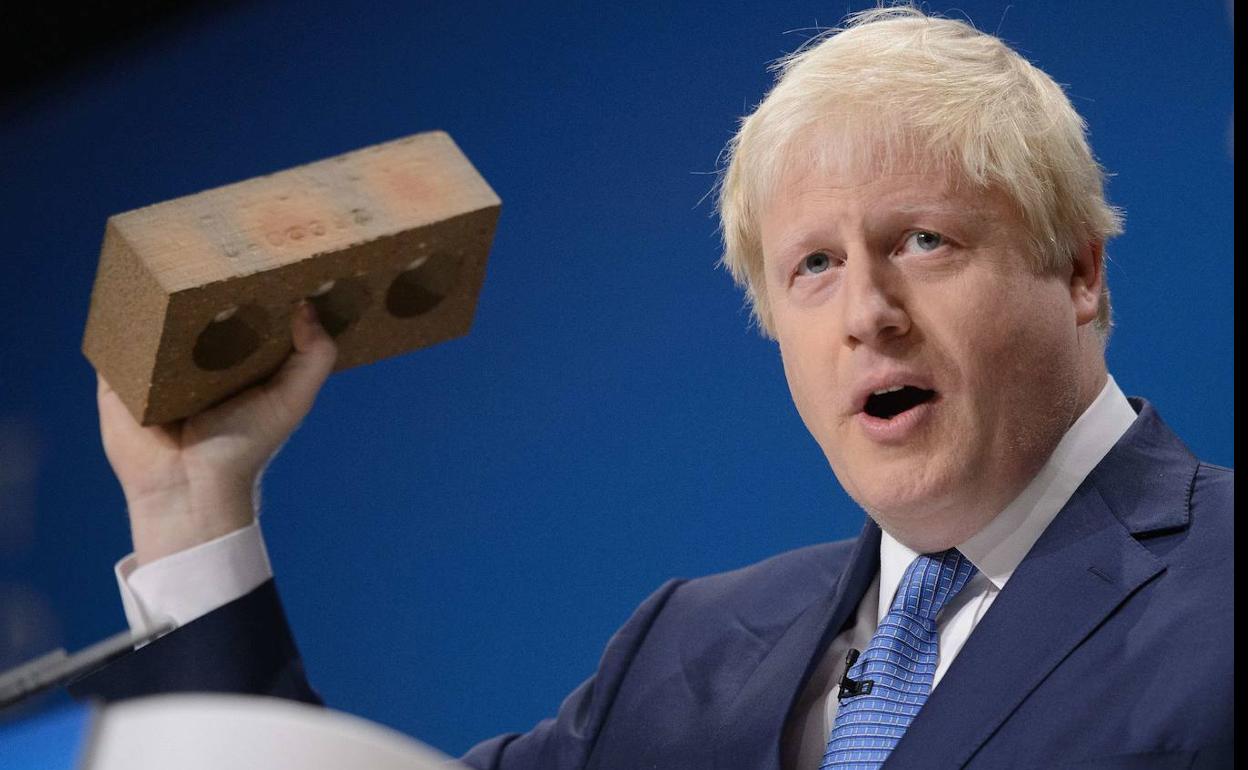 Boris Johnson muestra un ladrillo. 