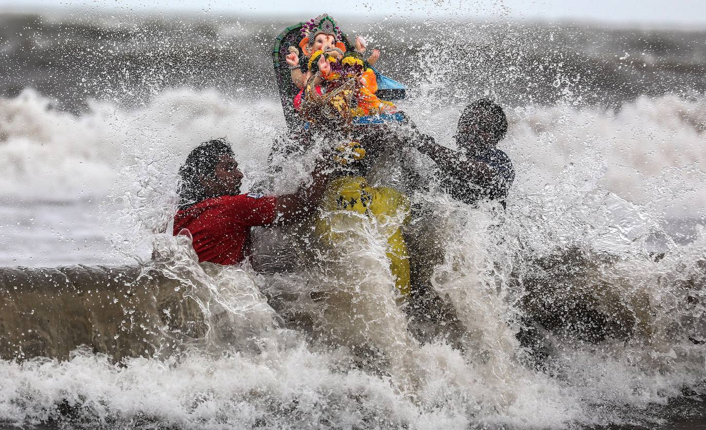 Indios devotos emergen en el mar Arábigo al dios con cabeza de elefante Ganesha durante la celebración del festival Ganesh Chaturthi, en Bombay (India). Esta celebración tiene lugar el cuarto día de la primera quincena del mes hindú Bhaadrapa, una jornada que coincide con el aniversario del nacimiento de Ganesha, hijo de Shiva y Parvati.