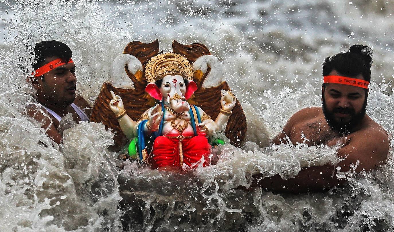 Indios devotos emergen en el mar Arábigo al dios con cabeza de elefante Ganesha durante la celebración del festival Ganesh Chaturthi, en Bombay (India). Esta celebración tiene lugar el cuarto día de la primera quincena del mes hindú Bhaadrapa, una jornada que coincide con el aniversario del nacimiento de Ganesha, hijo de Shiva y Parvati.