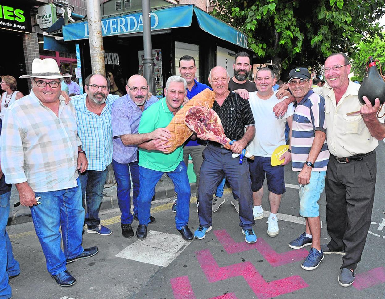 Peña El Chapi de La Arboleja, con jamón, bota de vino y pan de Barqueros. 