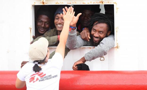 Migrantes rescatados celebran su llegada a Mesina. 