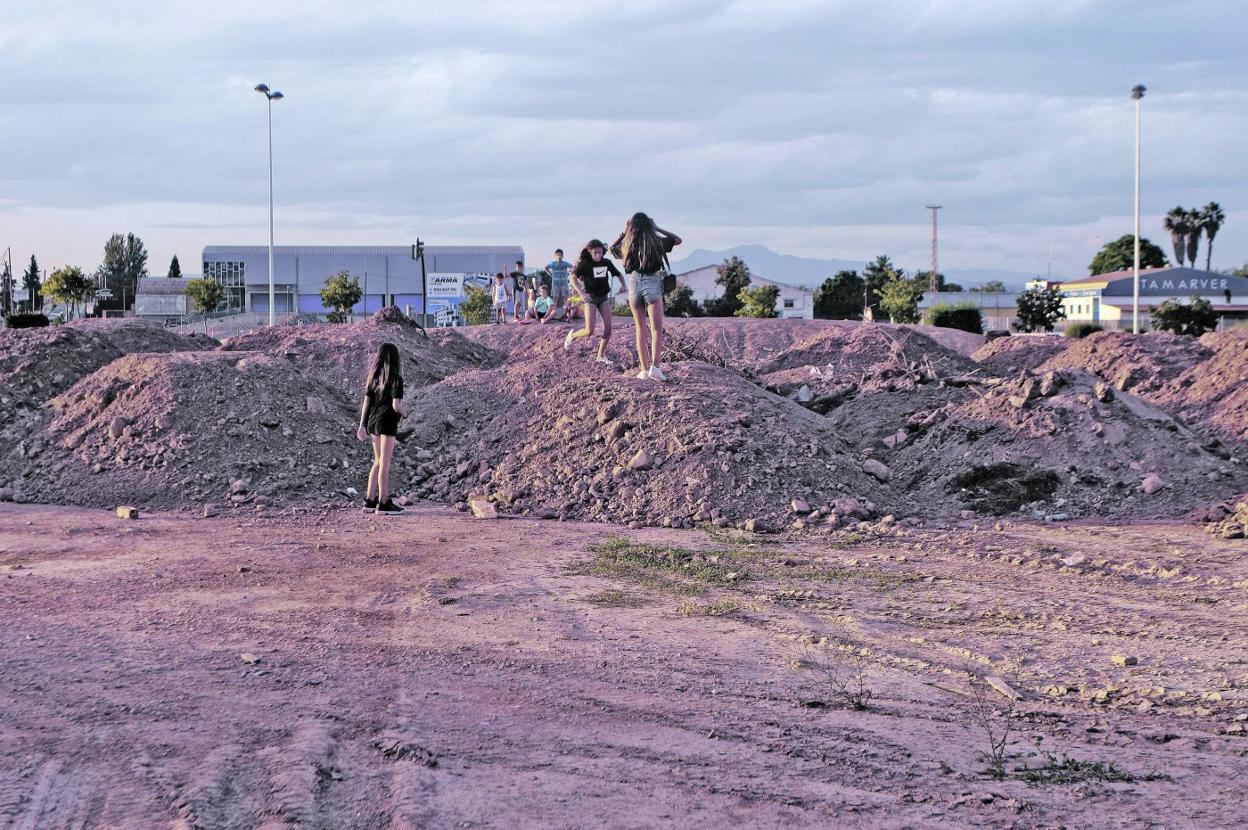 Varios niños juegan sobre los montones de barro y otros residuos ubicados en el solar. 