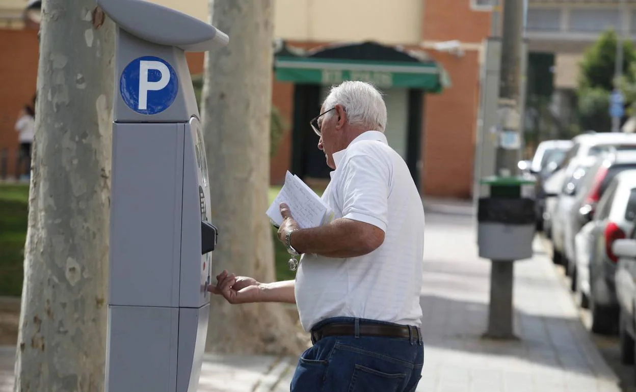 Un vecino de Murcia abona la tarifa de estacionamiento en zona azul.