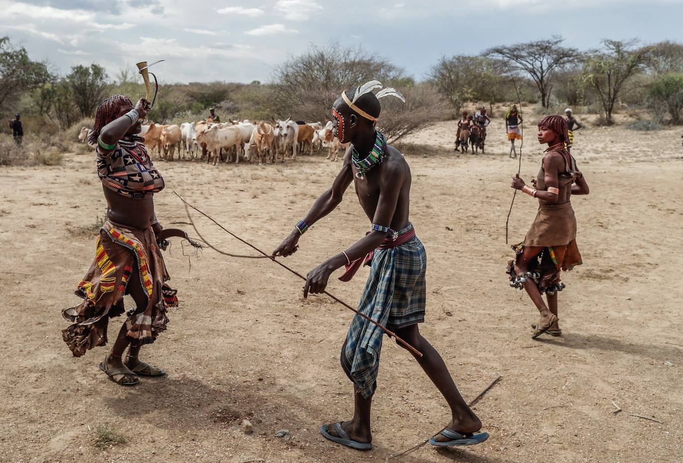 Los miembros de la tribu Hammer se preparan para la celebración de la ceremonia del 'salto del toro', un ritual que marca el paso a la edad adulta, en el pueblo de Turmi, al sur de Etiopía y cerca de la frontera con Kenia. En la ceremonia, el pequeño debe saltar por encima de siete toros para convertirse en un adulto.
