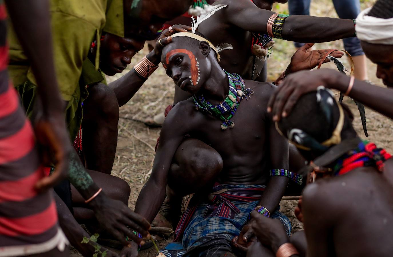 Los miembros de la tribu Hammer se preparan para la celebración de la ceremonia del 'salto del toro', un ritual que marca el paso a la edad adulta, en el pueblo de Turmi, al sur de Etiopía y cerca de la frontera con Kenia. En la ceremonia, el pequeño debe saltar por encima de siete toros para convertirse en un adulto.