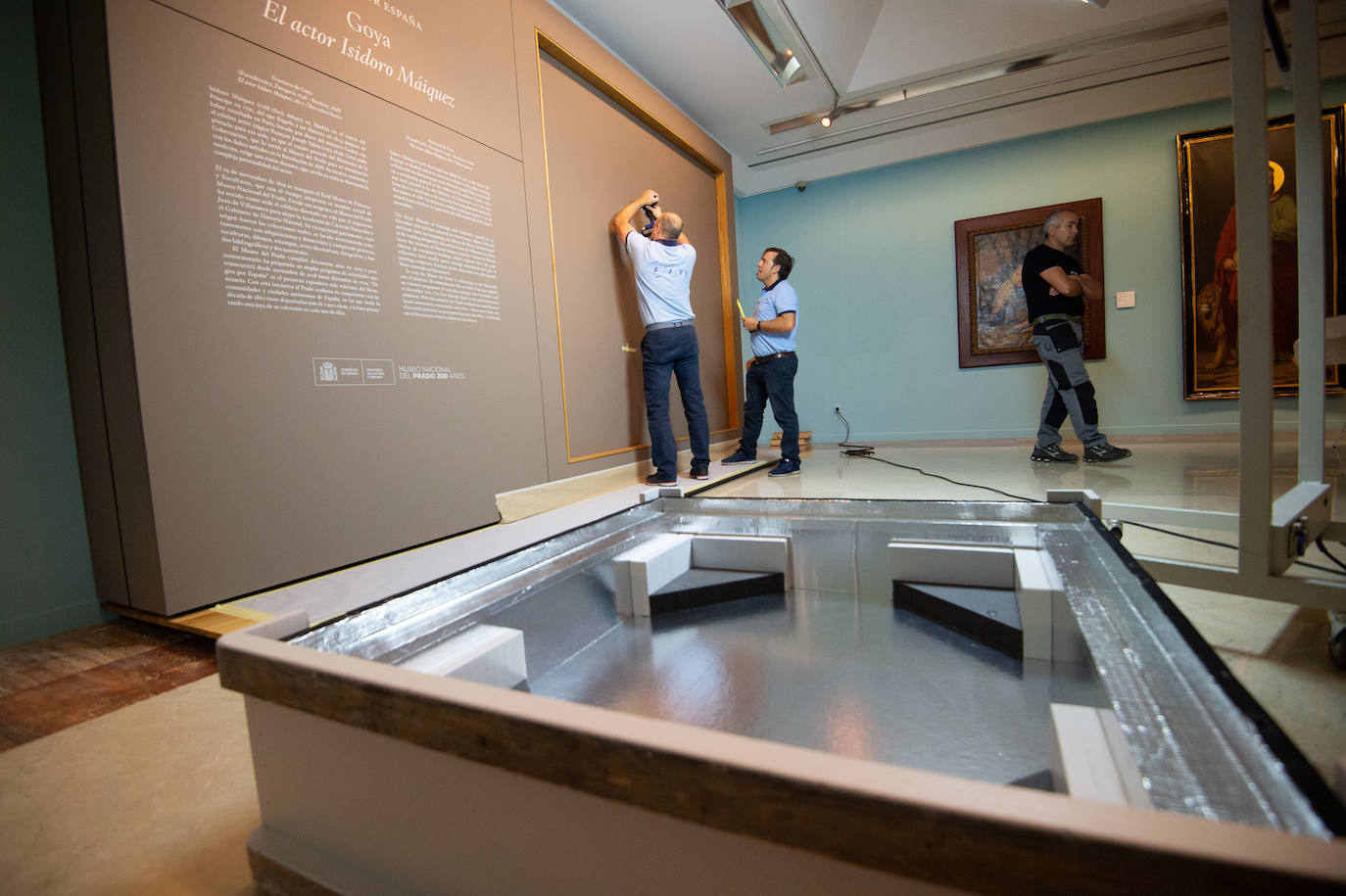 Dos técnicos cuelgan el retrato de Isidoro Máiquez, esta mañana en el Mubam.