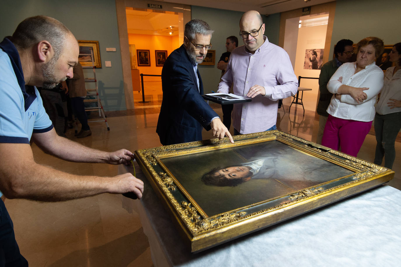 Dos técnicos cuelgan el retrato de Isidoro Máiquez, esta mañana en el Mubam.