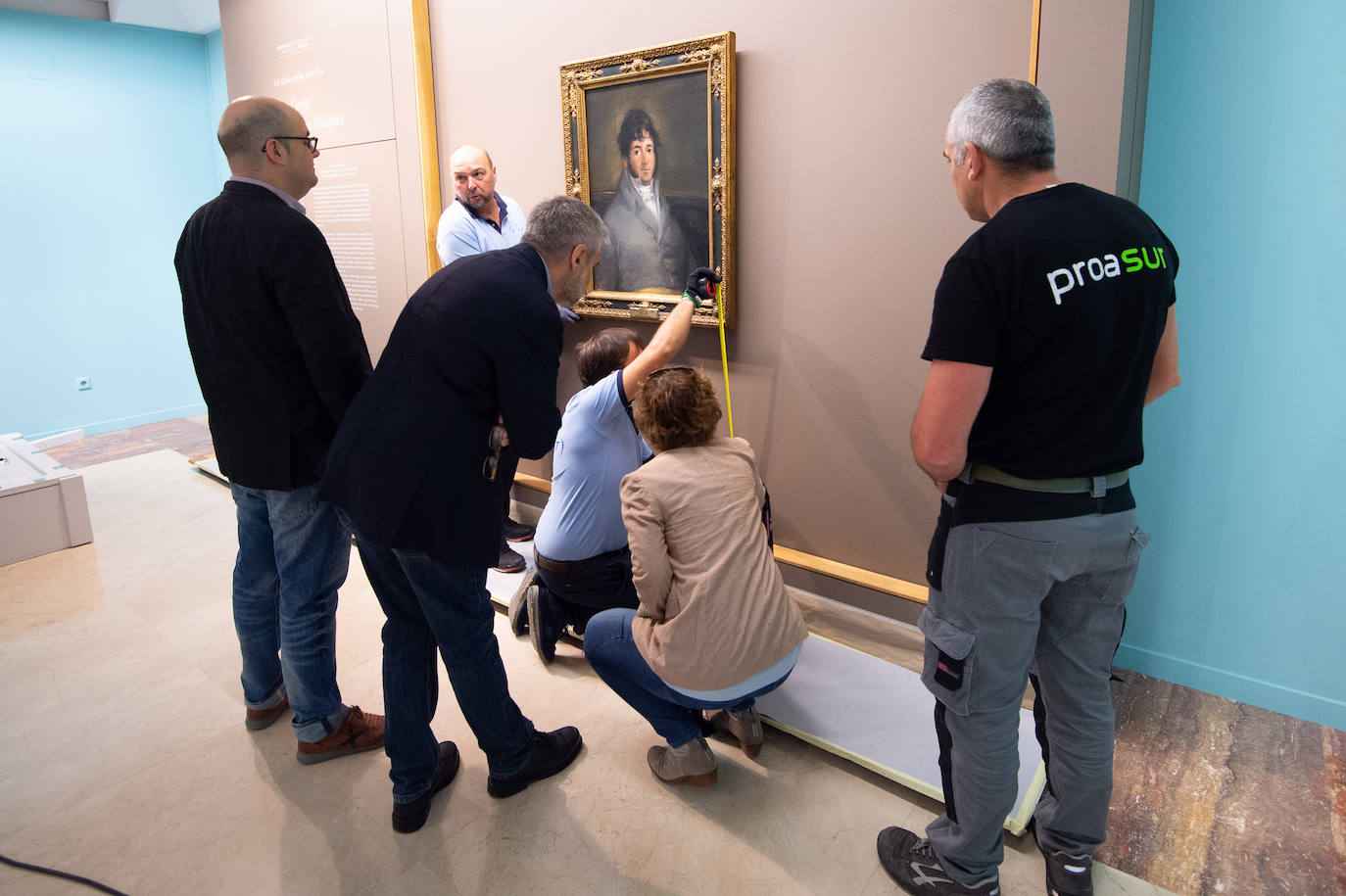 Dos técnicos cuelgan el retrato de Isidoro Máiquez, esta mañana en el Mubam.