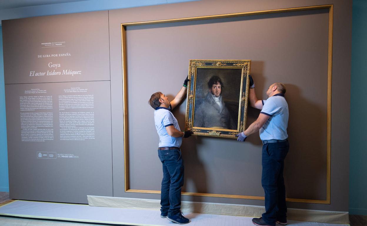 Dos técnicos cuelgan el retrato de Isidoro Máiquez, esta mañana en el Mubam. 