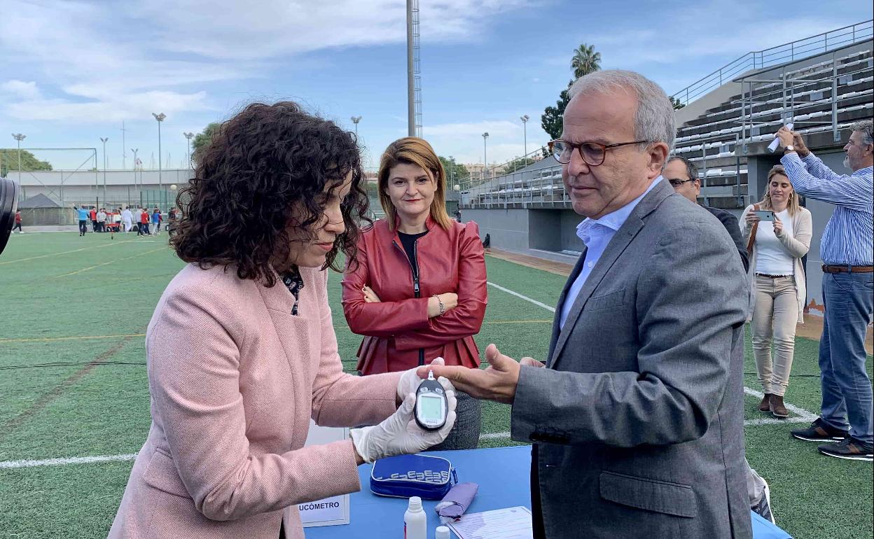 Encarni Martínez mide el nivel de glucosa al concejal Felipe Coello ante la mirada de Silvia Serrano.