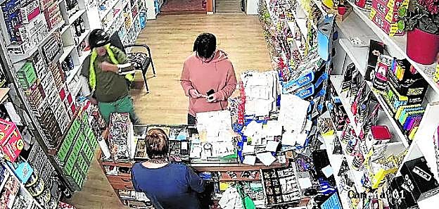 El ladrón entra al estanco y le pide el dinero a la mujer.