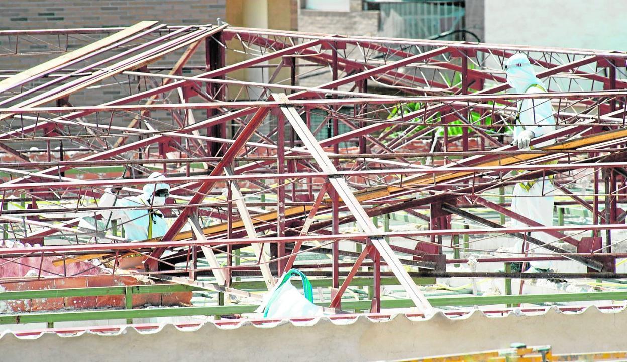 Varios operarios retiran una cubierta con amianto en un centro educativo de Santomera, en agosto de 2016. 