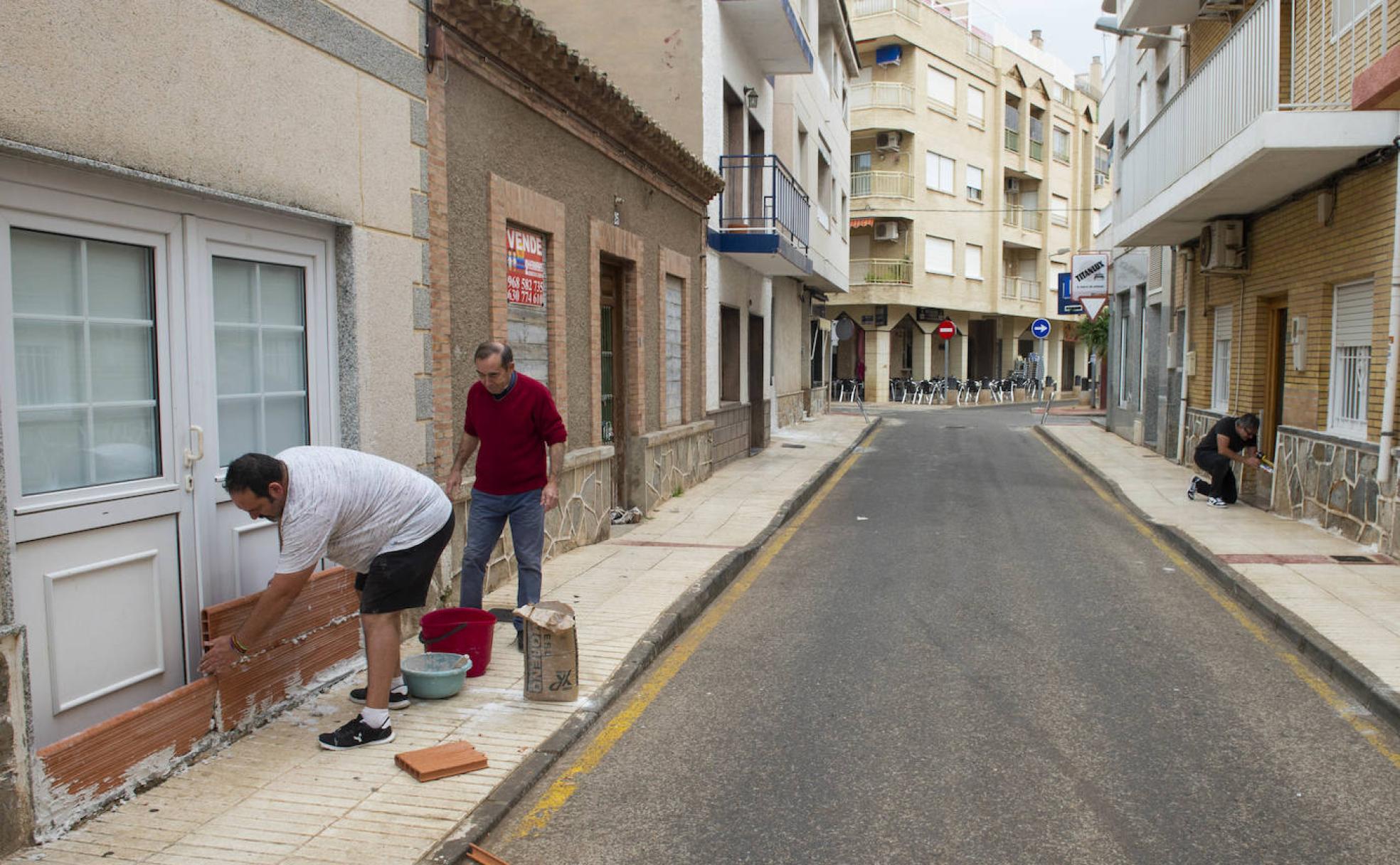 Vecinos de Los Alcázares tabican puertas de viviendas y comercios ante la alerta por gota fría. 